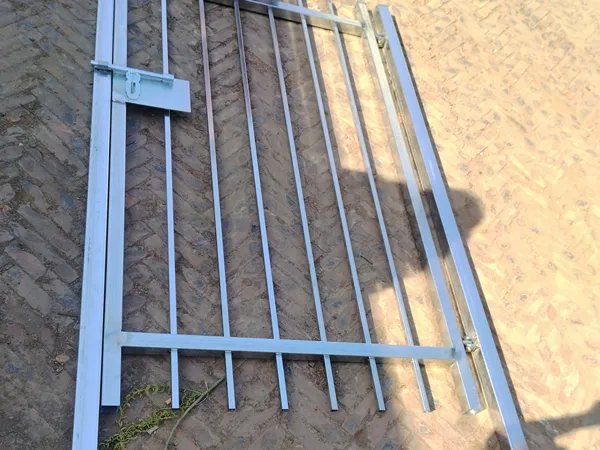 Full galvanized steel tubular fencing gate laid on brick ground