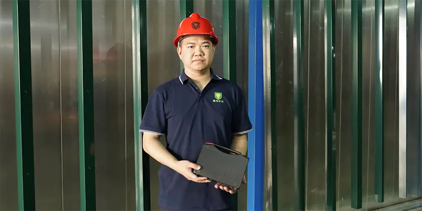 A QC worker is standing front of the powder coating line.