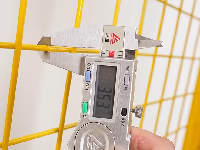 A QC worker is measuring the wire diameter of all welded workshop safety fence.