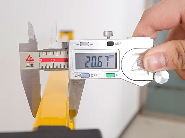 A QC worker is measuring the frame size of all welded workshop safety fence.