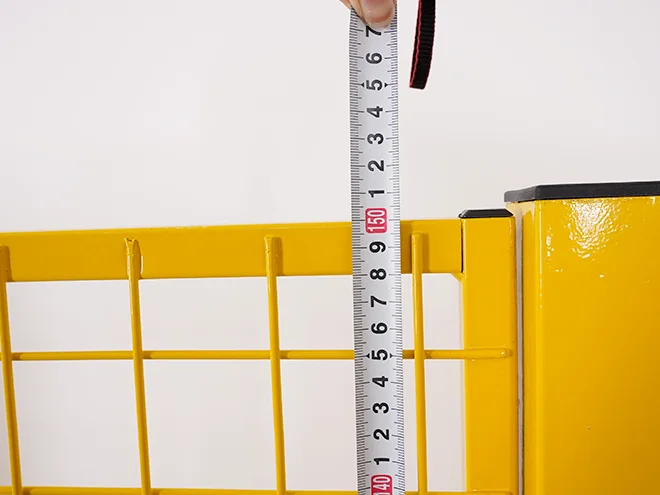 A QC worker is measuring the panel height of all welded workshop safety fence.