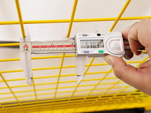 A QC worker is measuring the mesh size of all welded workshop safety fence.