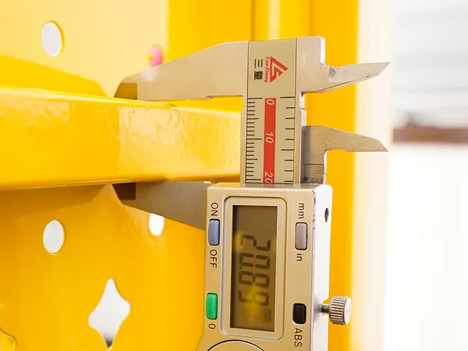 A QC worker is measuring the rail size of all welded workshop safety fence.