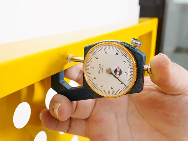 A QC worker is measuring the plate thickness of all welded workshop safety fence.