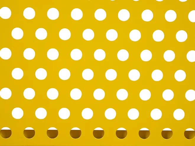 The detailed perforated metal structure of aisle workshop safety fence.